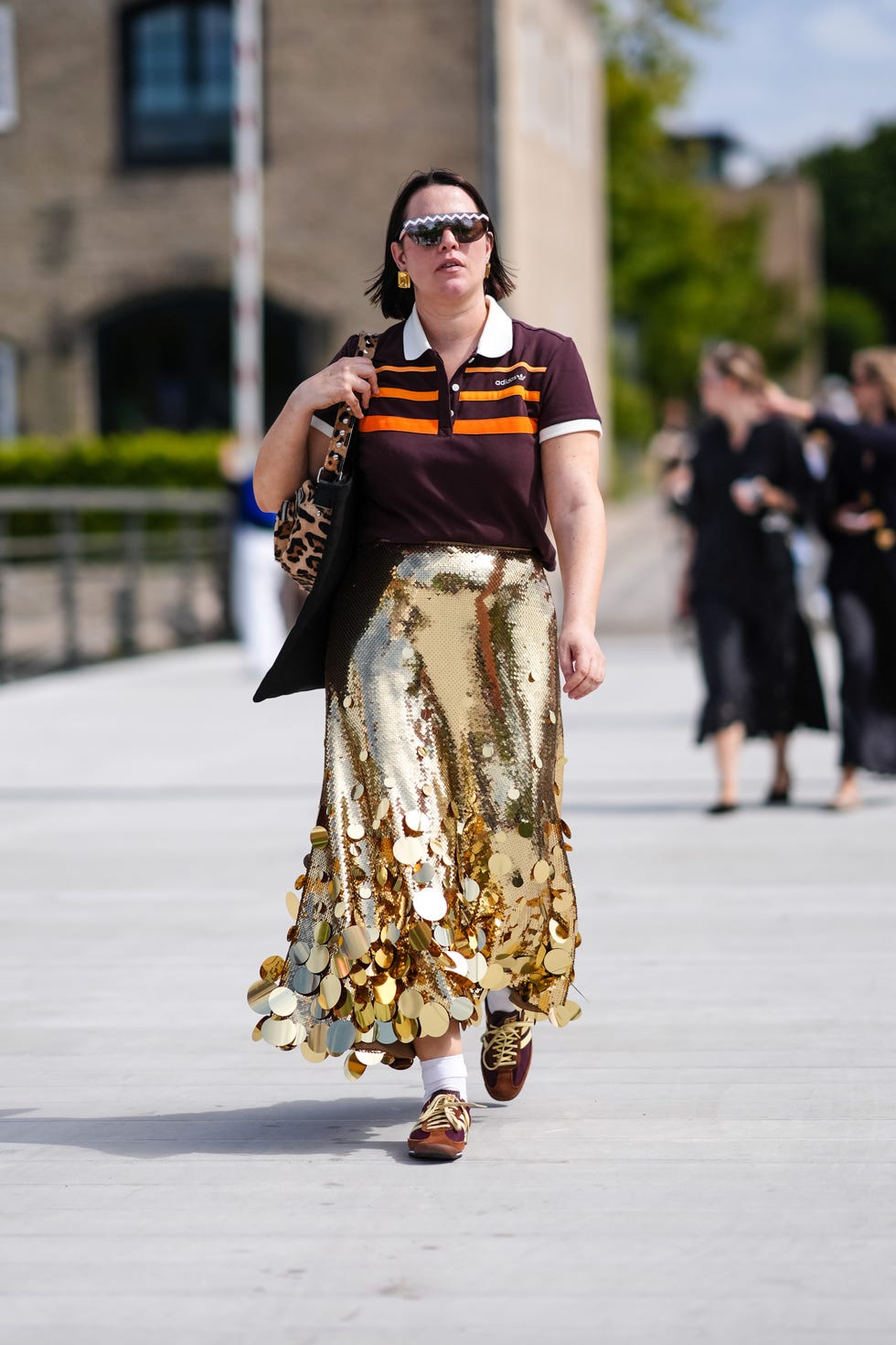 a street style photo of a guest at copenhagen fashion week wearing adidas sl 72 trainers