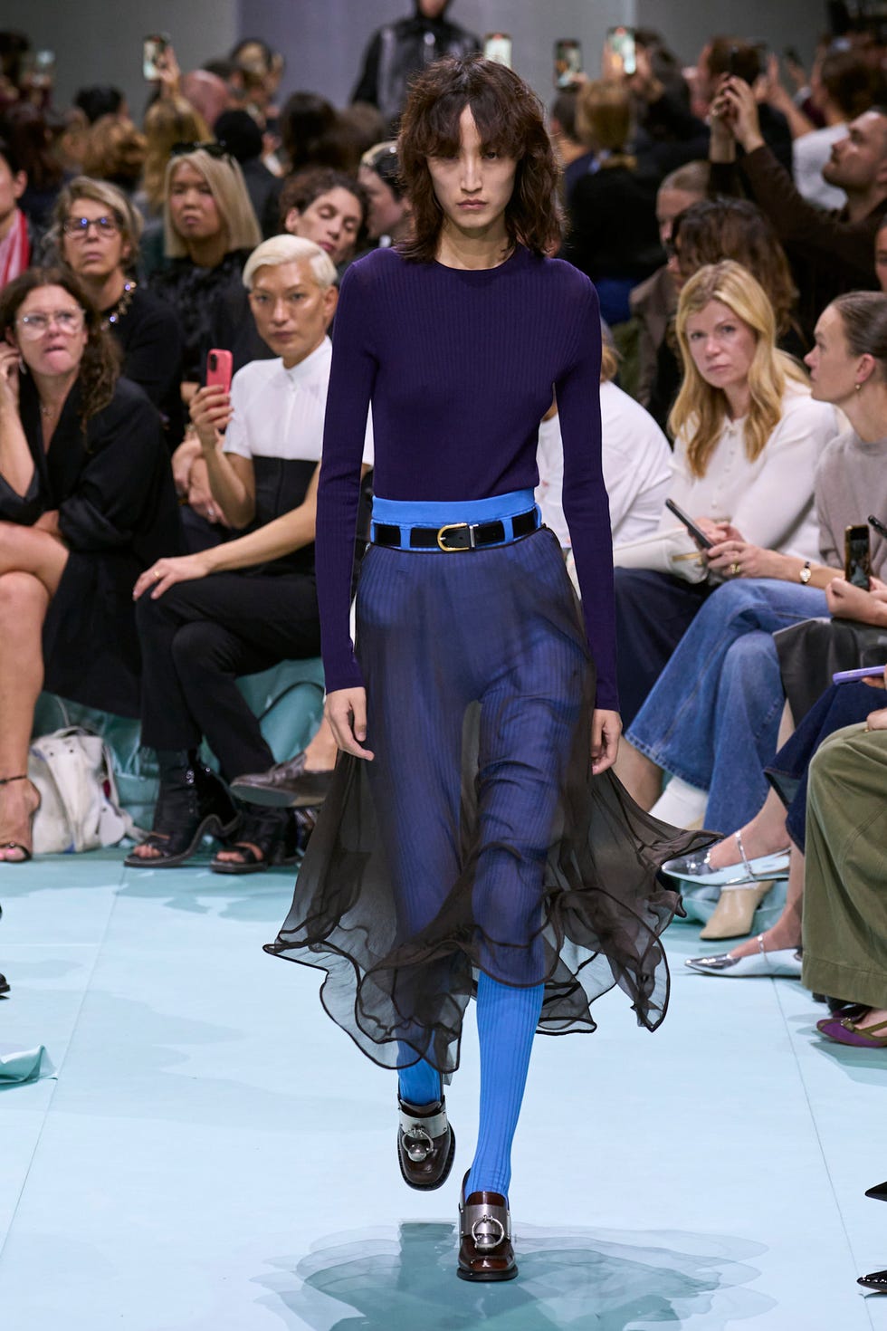 een model loopt op de catwalk tijden de prada show